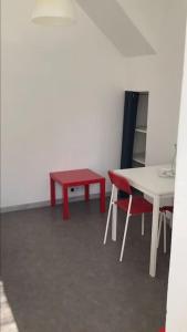 a room with a table and a red table and chairs at Studio au centre de Quimper RDC in Quimper
