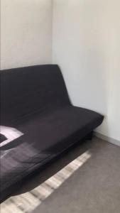a black bed in the corner of a room at Studio au centre de Quimper RDC in Quimper