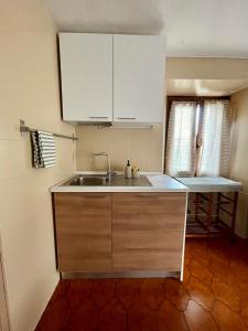 eine Küche mit weißen Schränken und einem Waschbecken in der Unterkunft Maison Merlot in Aosta