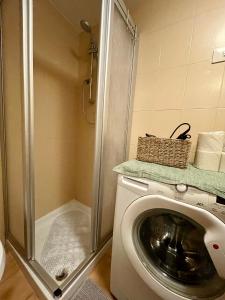 a washing machine in a bathroom with a shower at Maison Merlot in Aosta