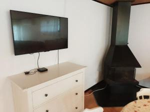 een woonkamer met een tv en een dressoir met een open haard bij Holiday house in Grythem, Orebro, within walking distance to lake in Örebro