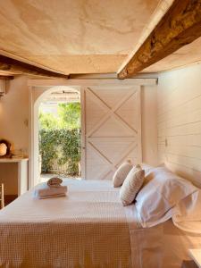 una camera con letto bianco e porta scorrevole nel fienile di Casa Lucia a Sorrento