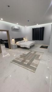 a white bedroom with a bed and a window at Manazel Al Faisal Furnished Apartments in Al Baha