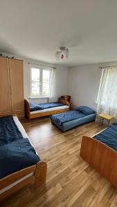 een kamer met 3 bedden en een houten vloer bij Hostel Łódźka 52 in Toruń