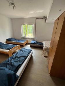 een kamer met 3 bedden en een raam bij Hostel Łódźka 52 in Toruń