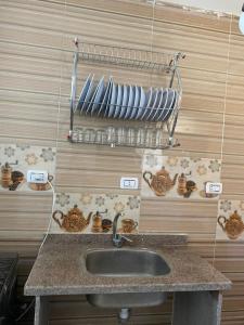 a kitchen with a sink and a shelf with dishes at مرسى مطروح in Marsa Matruh