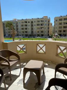 a balcony with chairs and a table and buildings at مرسى مطروح in Marsa Matruh