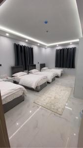 Un grupo de 4 camas en una habitación en Manazel Al Faisal Furnished Apartments en Al Baha