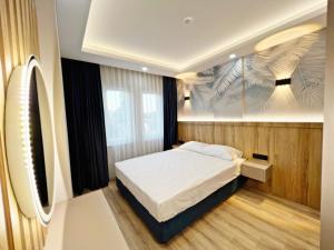 a bedroom with a bed and a painting on the wall at Kemer Sunrise Suit in Kemer