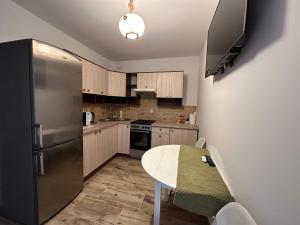 a kitchen with a table and a stainless steel refrigerator at Mirabella House in Rzeszów