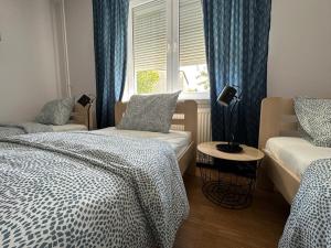 sypialnia z 2 łóżkami i oknem z niebieskimi zasłonami w obiekcie Mirabella House w mieście Rzeszów