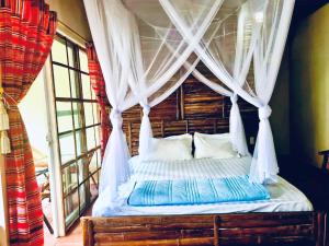Palm Hill Chalet في ها زانغ: غرفة نوم مع سرير مظلة مع ستائر بيضاء