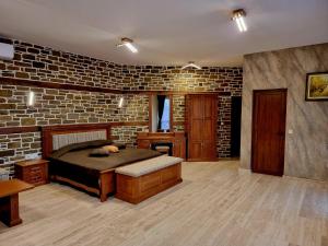 sypialnia z łóżkiem i ceglaną ścianą w obiekcie Семеен Хотел Чардаците w mieście Lovech