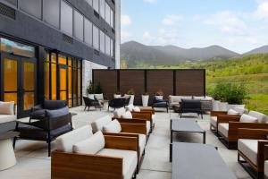 une terrasse d'un immeuble avec des canapés et des tables dans l'établissement AC Hotel by Marriott Frisco Colorado, à Frisco