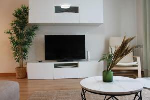 una sala de estar con un centro de entretenimiento blanco con TV de pantalla plana en Apartamento Turístico HB, en Villafranca