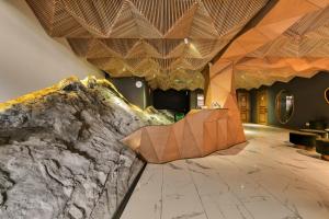 a lobby with a stone wall and wooden ceiling at Amante Narikala Boutique Hotel in Tbilisi City