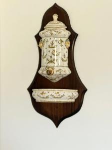 a mirror hanging on a wall with a vase at Chateau de la Clapiere in Hyères