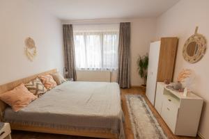 a bedroom with a bed and a large window at Park apartman - központi, csendes, családbarát in Odorheiu Secuiesc
