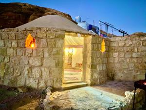 a stone building with a window and a stone wall at Pink city cottage in Wadi Musa
