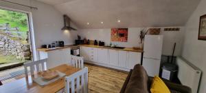cocina con mesa y nevera blanca en Windsor Cottage for Scafell and Wasdale, en Nether Wasdale