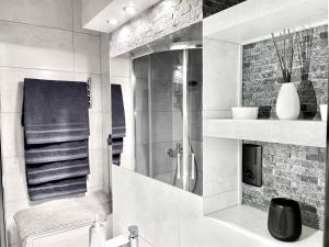 a white bathroom with a shower and a sink at Apartament Zielony Mokotów in Warsaw