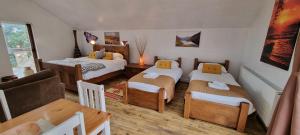 um quarto com três camas e uma mesa e cadeiras em Windsor Cottage for Scafell and Wasdale em Nether Wasdale