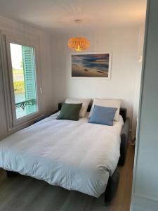 - une chambre avec un lit avec deux oreillers et une fenêtre dans l'établissement La loge en baie, à Saint-Valery-sur-Somme
