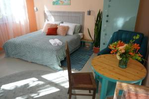 a bedroom with a bed and a table with a vase of flowers at Uliha Apartamenti in Liepāja
