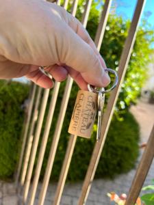 a person holding a pair of keys in front of a bench at Chateau de la Clapiere in Hyères