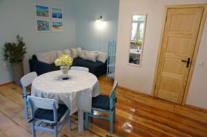 a living room with a table and chairs and a couch at Uliha Apartamenti in Liepāja