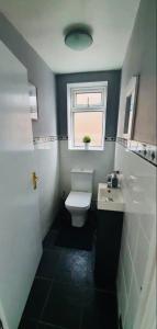 a bathroom with a toilet and a sink and a window at Cosy room Maidstone in Kent