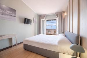 a bedroom with a bed and a table and a window at Hotel Baia Imperiale in Campo nell'Elba