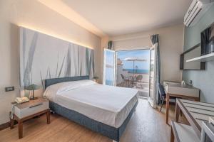 a bedroom with a bed and a balcony at Hotel Baia Imperiale in Campo nell'Elba