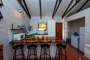 a kitchen with a counter and four bar stools at Boscia Farmstay in George