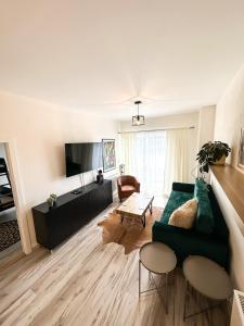 Una sala de estar con un sofá verde y un televisor. en Holiday Flat, en Liptovský Mikuláš