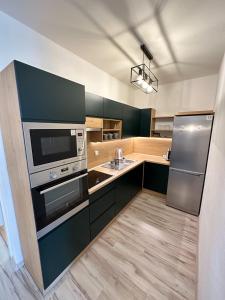 a kitchen with stainless steel appliances and a sink at Holiday Flat in Liptovský Mikuláš