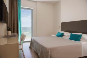 - une chambre avec un lit et une grande fenêtre dans l'établissement Hotel delle Nazioni, à Pesaro