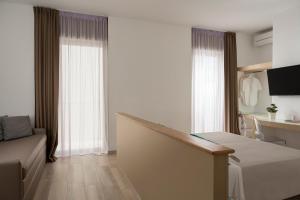 a hotel room with a bed and a couch and windows at Hotel delle Nazioni in Pesaro +99 photos