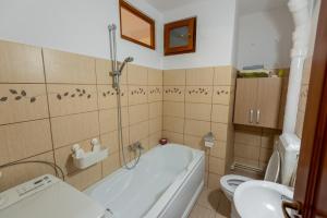 a bathroom with a tub and a toilet and a sink at Park apartman - központi, csendes, családbarát in Odorheiu Secuiesc
