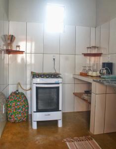 a small kitchen with an oven in the middle at Bangalôs do Tapajós in Alter do Chao