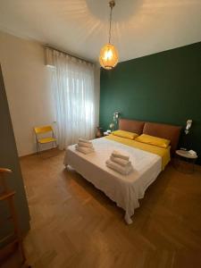 a bedroom with a large bed with a green wall at Casa Sivori sul lago di Garda con ampio giardino in Desenzano del Garda