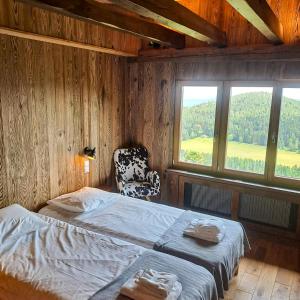 1 dormitorio con 1 cama, 1 silla y ventanas en Le Schallern - Accès à pieds depuis le Gaschney en Muhlbach-sur-Munster