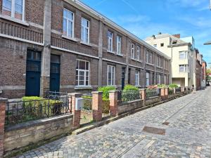eine Kopfsteinpflasterstraße vor einem Backsteingebäude in der Unterkunft Huis ALNA 3 in Mechelen
