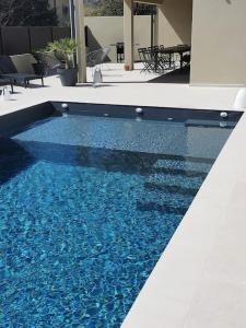 una piscina con agua azul en un edificio en GRAND GîTE AUGUSTA, en Ruoms