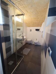 een badkamer met 2 toiletten en een glazen douche bij L'otto in Mesagne