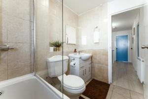 ein Bad mit einem WC, einem Waschbecken und einer Dusche in der Unterkunft Stratford Cosy rooms - 17 in London