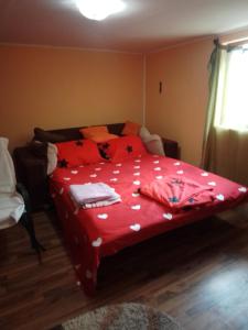 的住宿－Casa Mocanu 2，一间卧室配有一张红色棉被的床