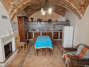 eine Küche mit einem Tisch und einem Kühlschrank im Zimmer in der Unterkunft Casa Collarano in San Demetrio neʼ Vestini + 4 Fotos