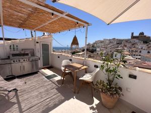 アルテアにあるCasa Kai Altea - Torre de Bellaguardaのバルコニーにテーブルと椅子が置かれたパティオ