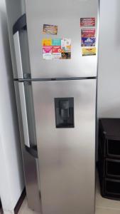 a white refrigerator with magnets and papers on it at Apartamento 2 habitaciones aire acondicionado en Sopetran Unidad res Piscinas sol y descanso in Sopetran